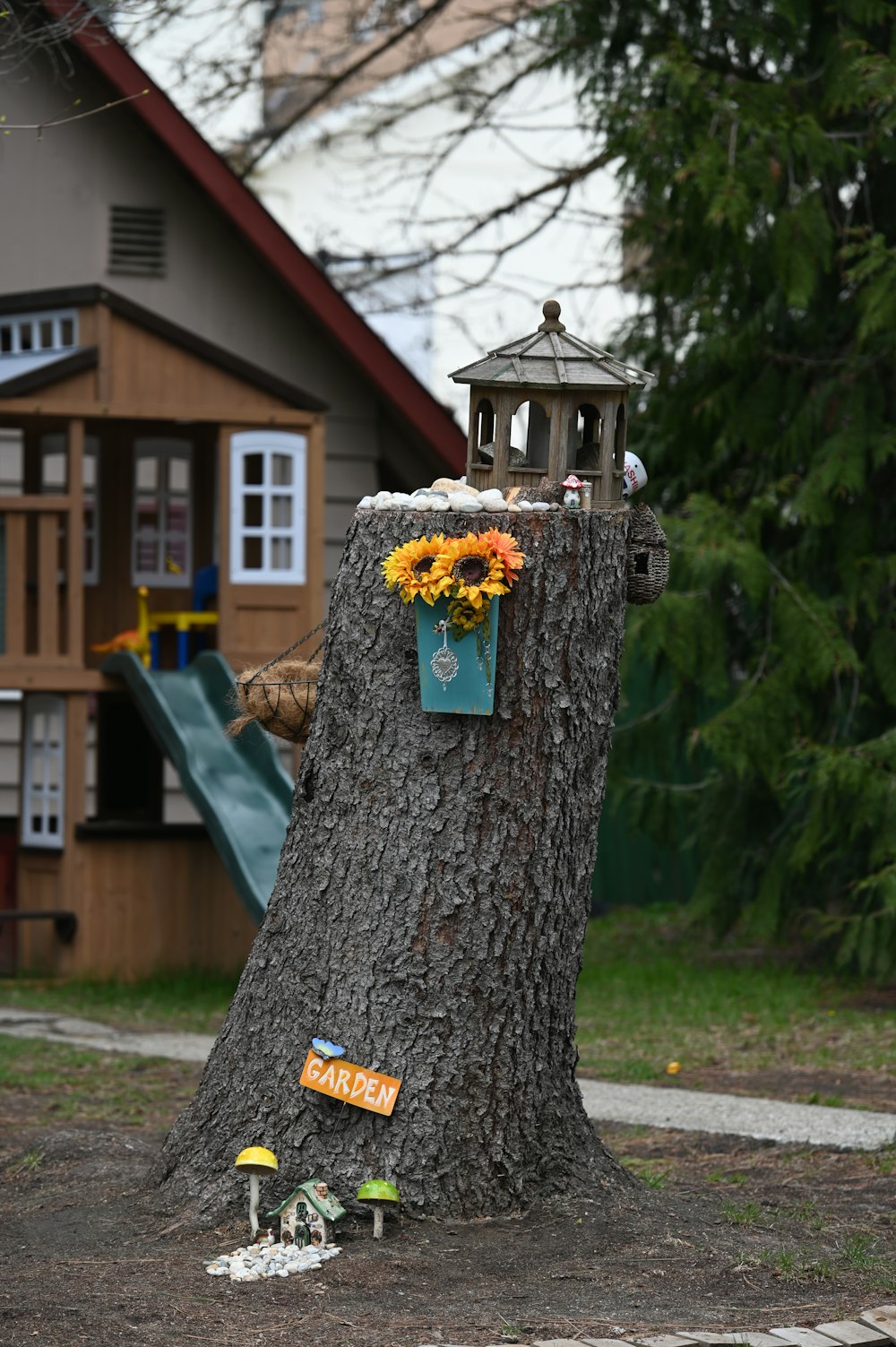 a tree stump with a birdhouse on top of it