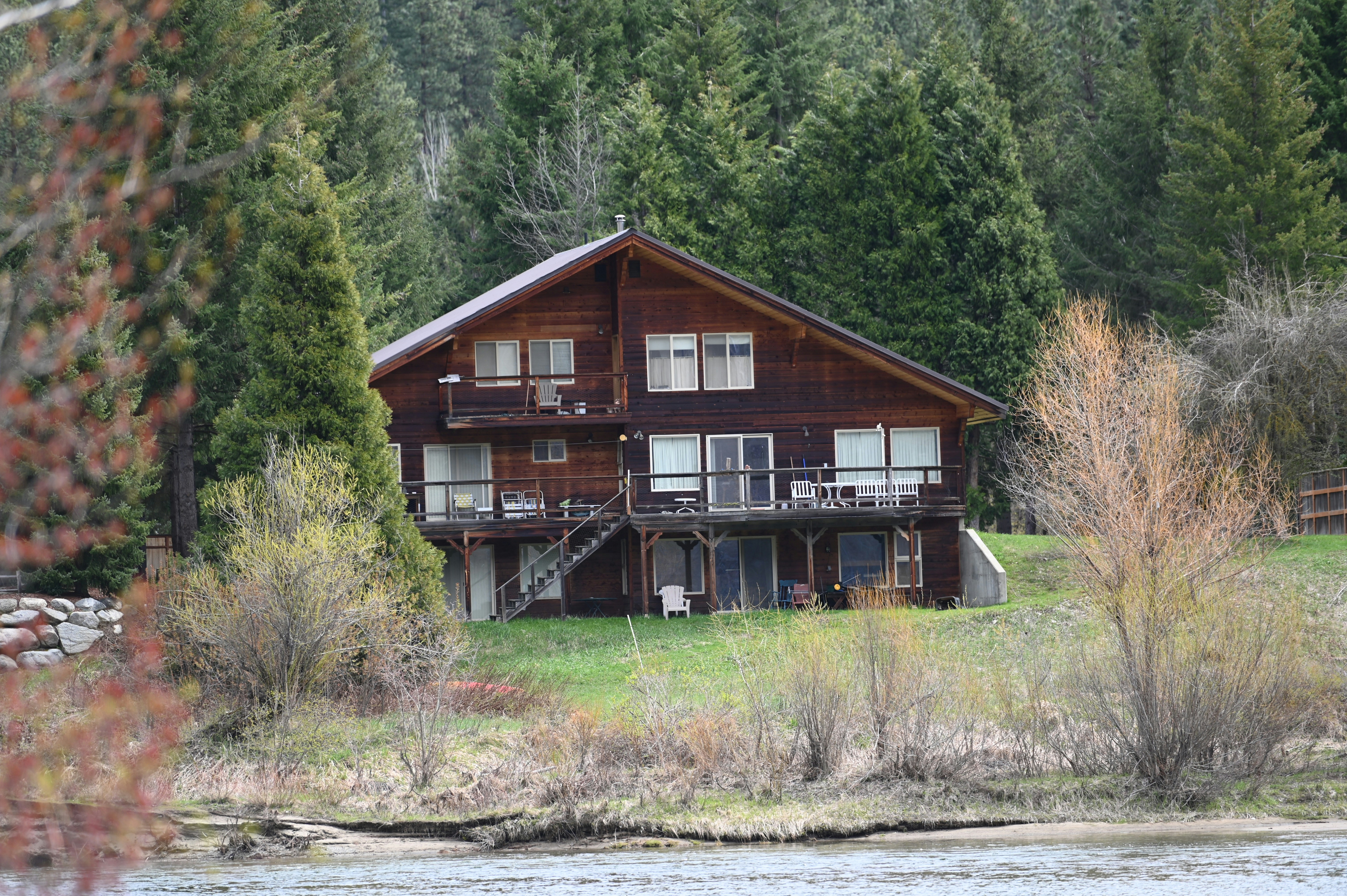 a large wooden house sitting on top of a lush green field