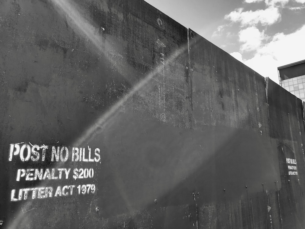 a black and white photo of a sign on a wall