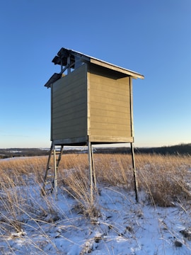 A team installing a deer stand in the woods.