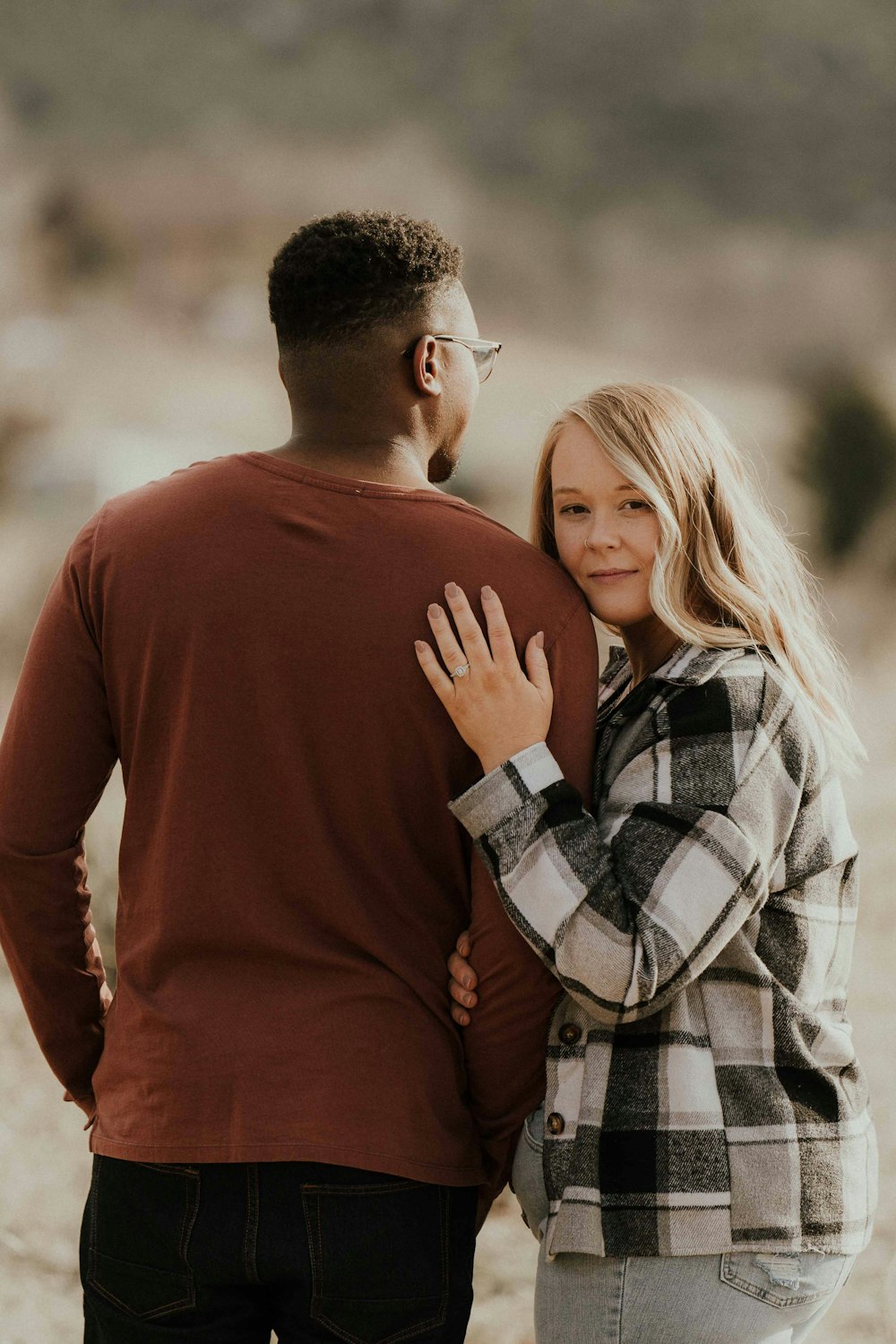 a man standing next to a woman in a plaid shirt