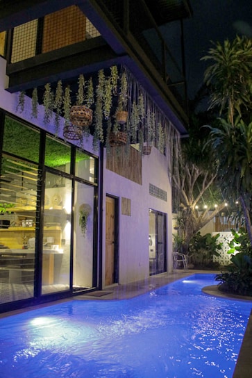 a swimming pool in front of a building at night