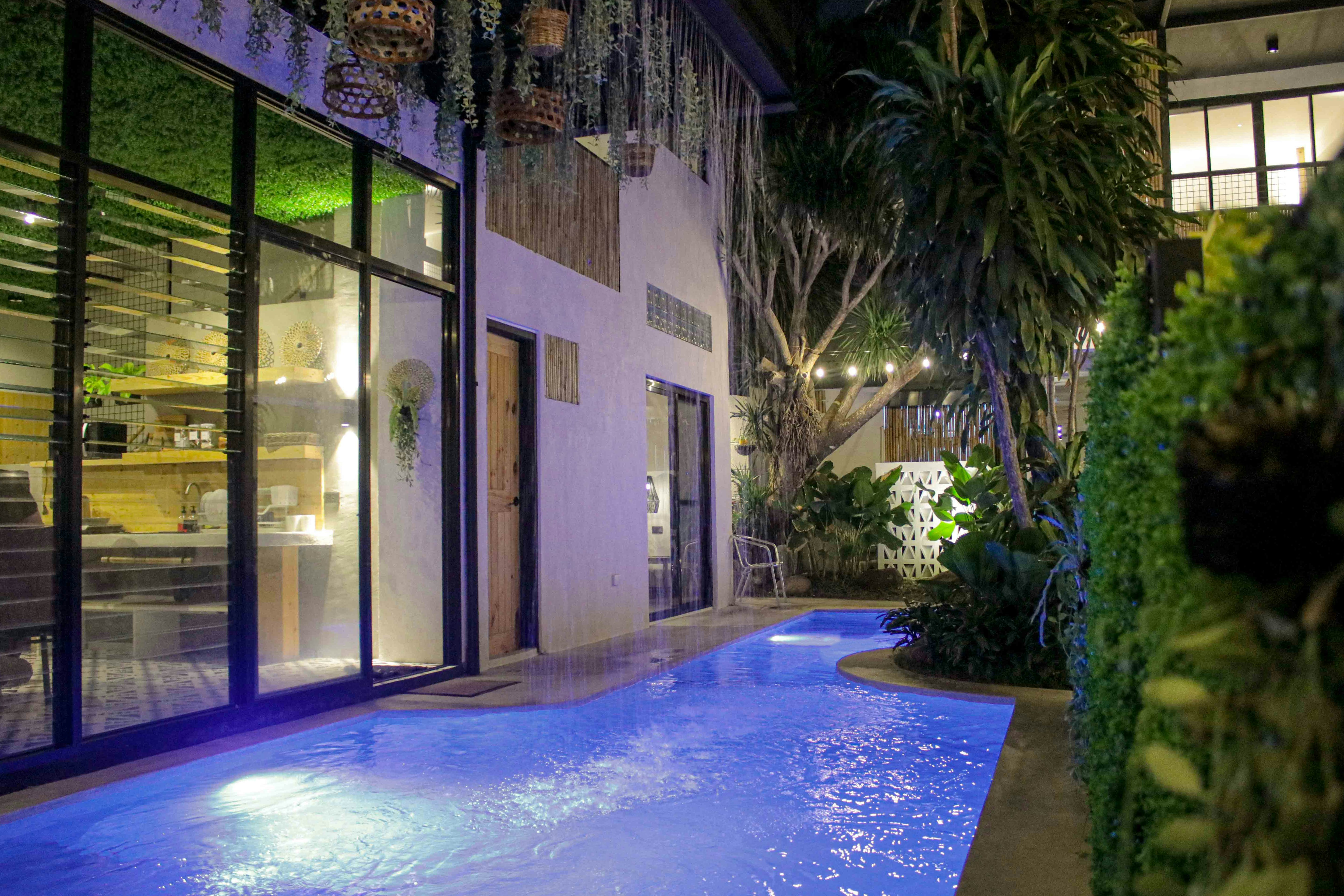 a swimming pool in front of a building at night