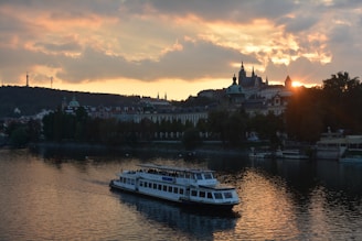 A scenic view of the Danube River at sunset with a cruise boat gliding gracefully.