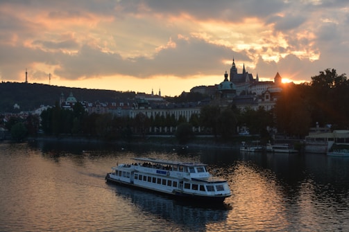 A scenic view of the Danube River at sunset with a cruise boat gliding gracefully.