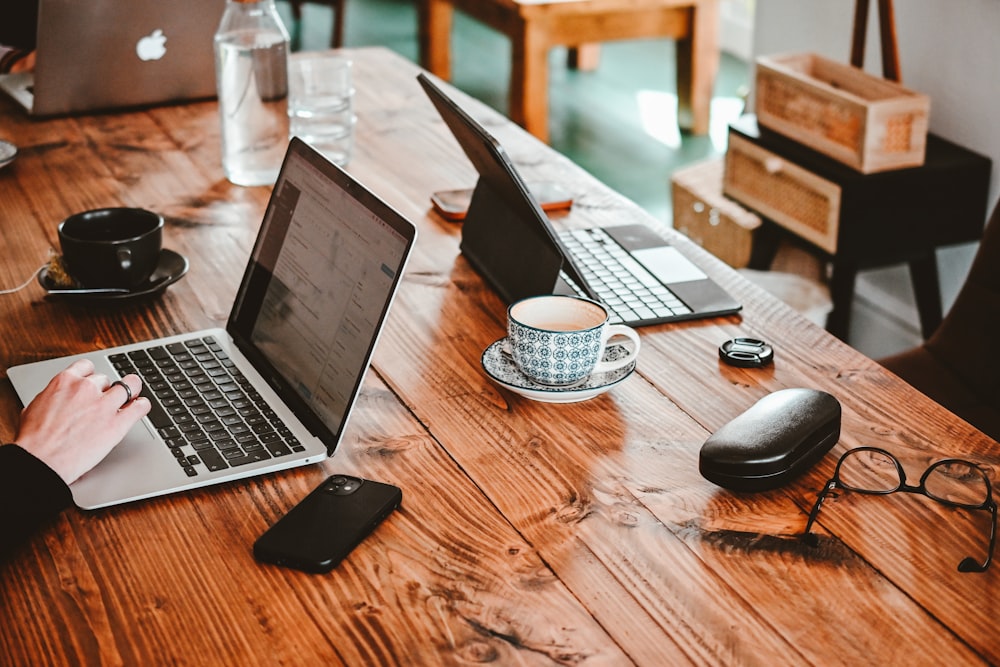 a person using a laptop on a wooden table