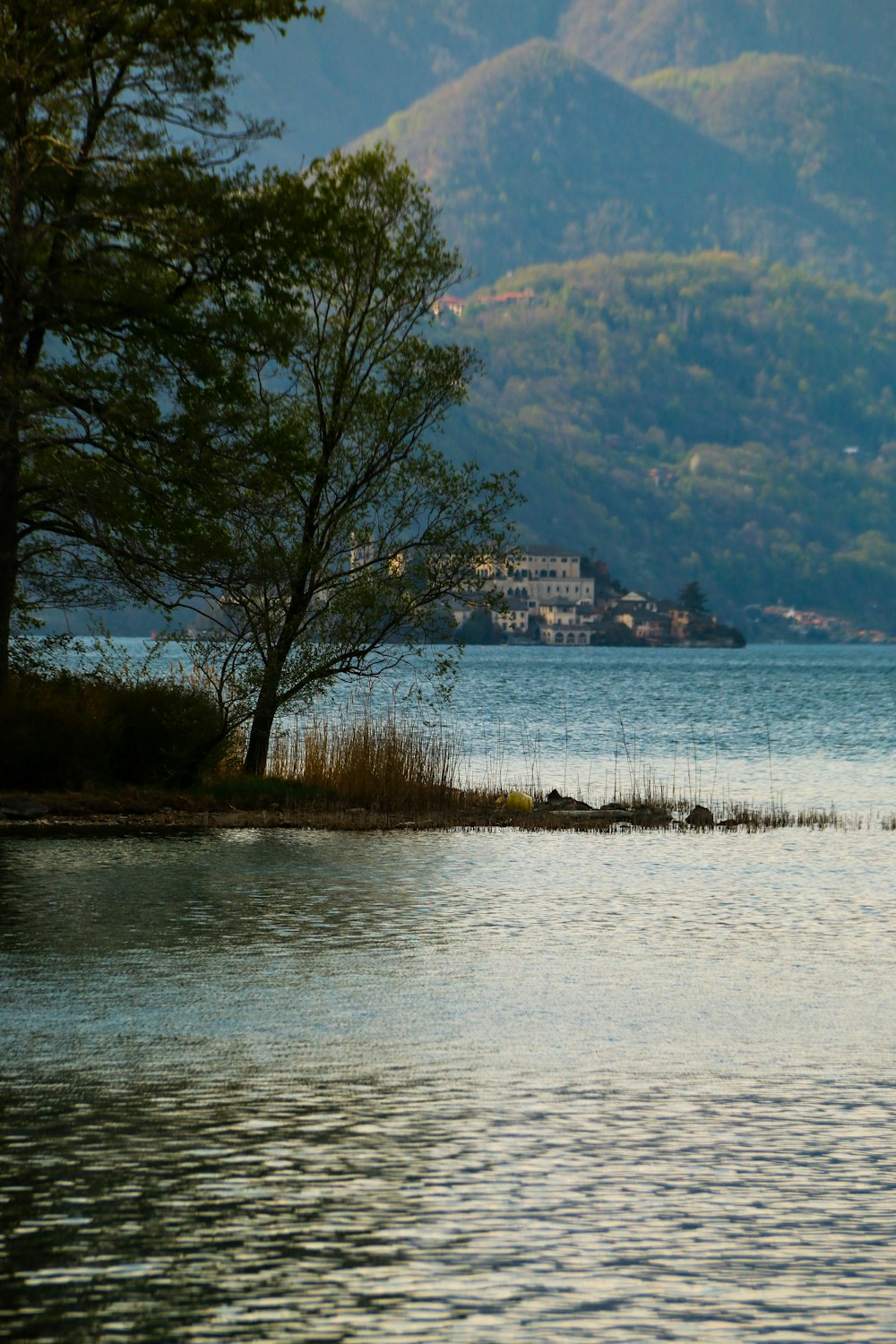 a lone boat floating on a lake surrounded by mountains