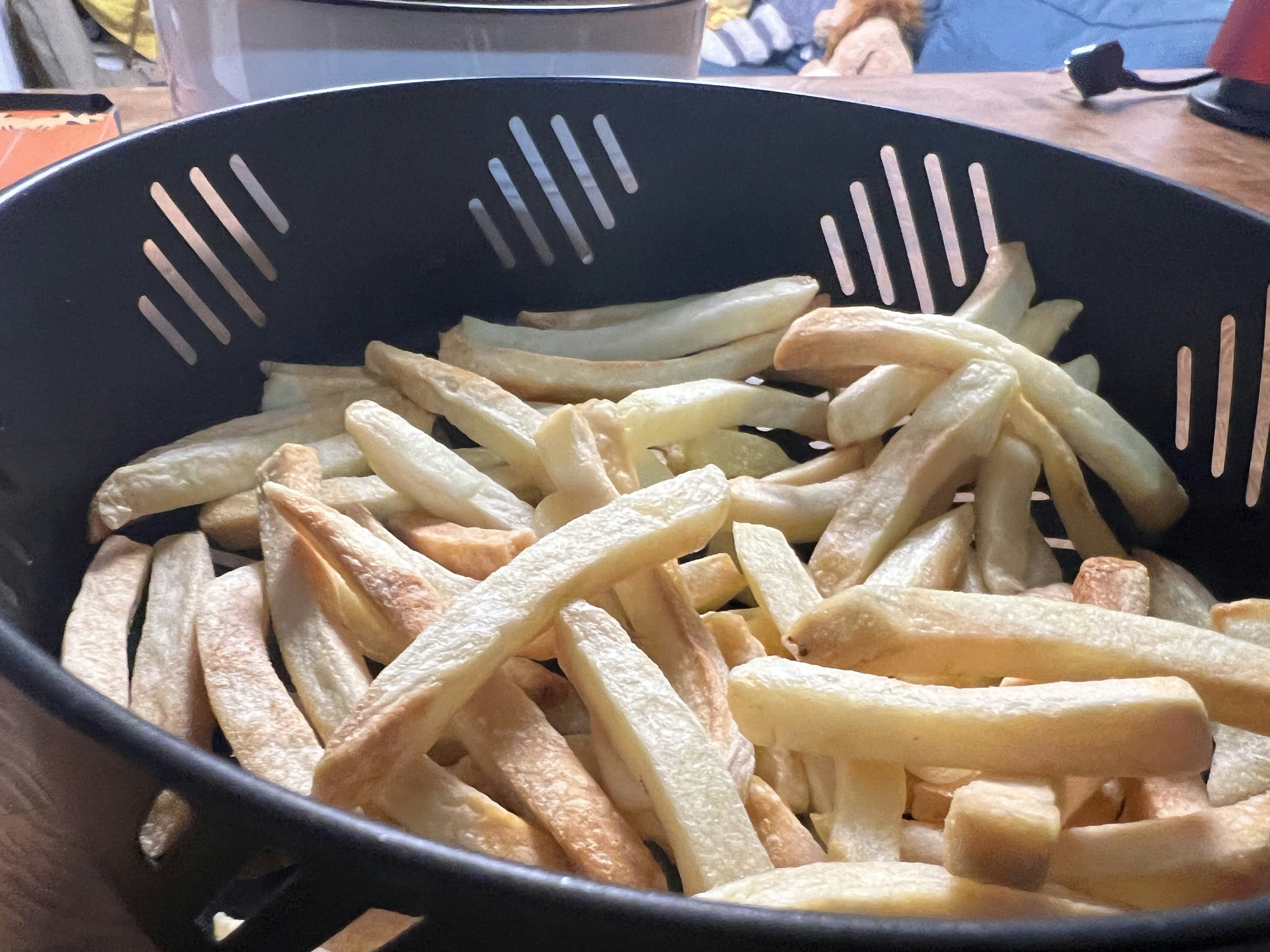 Gouden frietjes in een airfryermandje, testopstelling met meetlat voor gelijkmatigheid