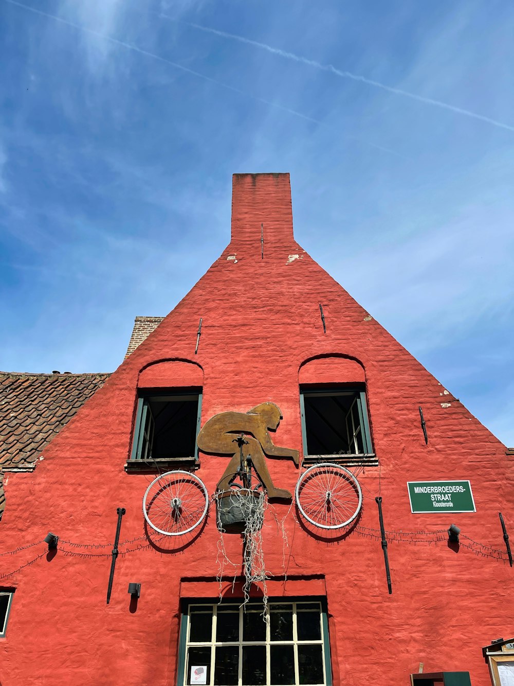 a red brick building with a bicycle sculpture on the front of it