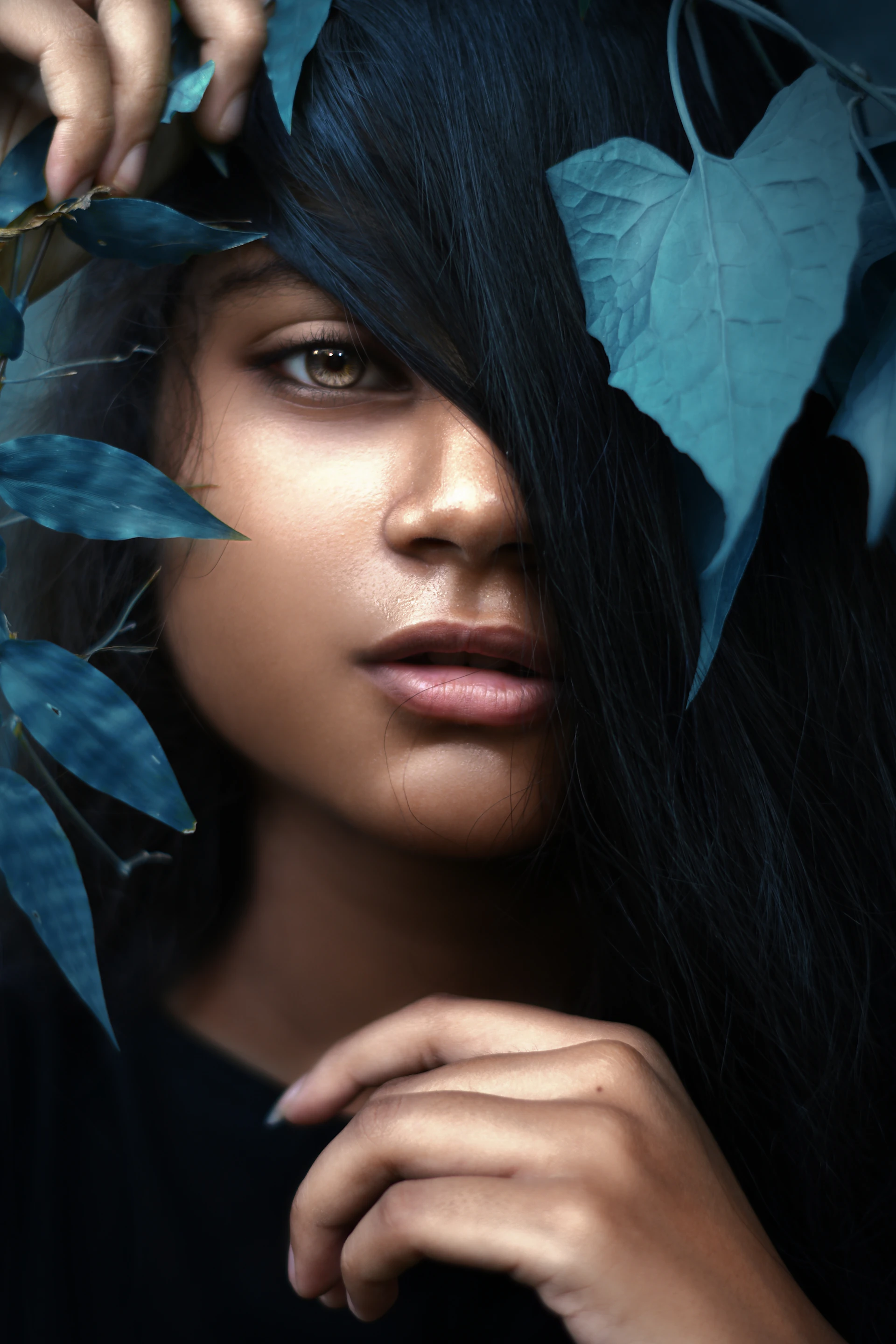 a woman with long black hair and leaves around her head