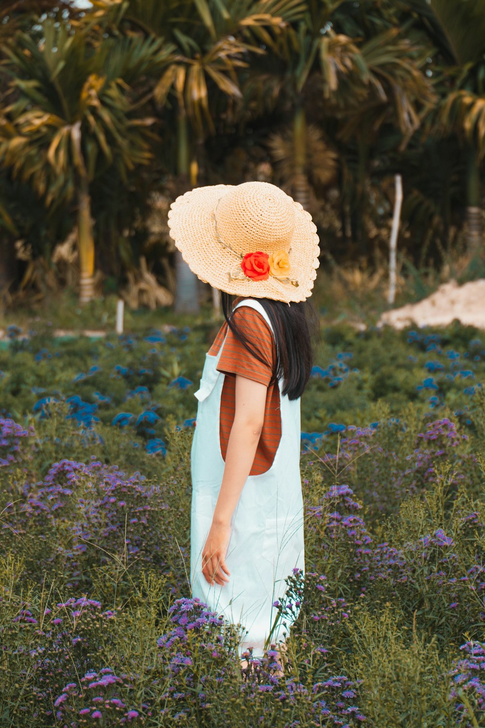 a woman standing in a field of purple flowers