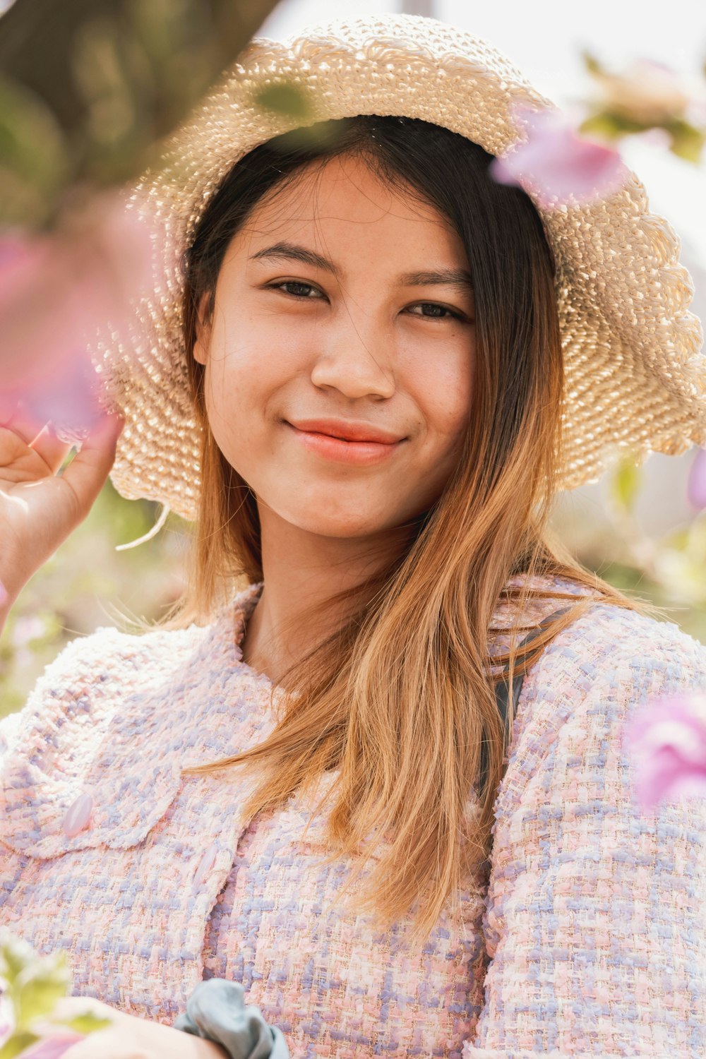 a young woman wearing a straw hat in a field of flowers