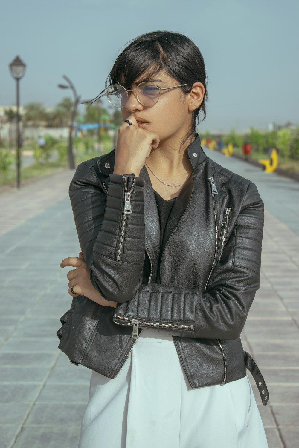 a woman wearing a black leather jacket and glasses