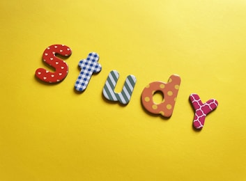 a word made out of wooden letters sitting on top of a yellow surface