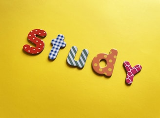 a word made out of wooden letters sitting on top of a yellow surface