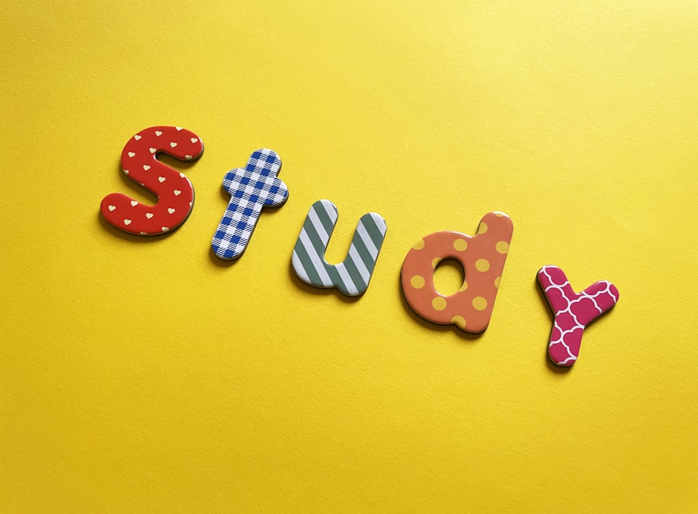 Una parola fatta di lettere di legno sedute sopra una superficie gialla