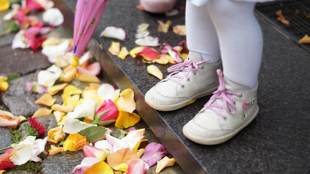 a person standing on a step with flowers on the ground
