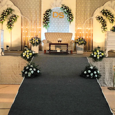 A beautifully decorated wedding stage at K.S. Vivah with golden drapes and elegant floral arrangements under soft warm lighting.