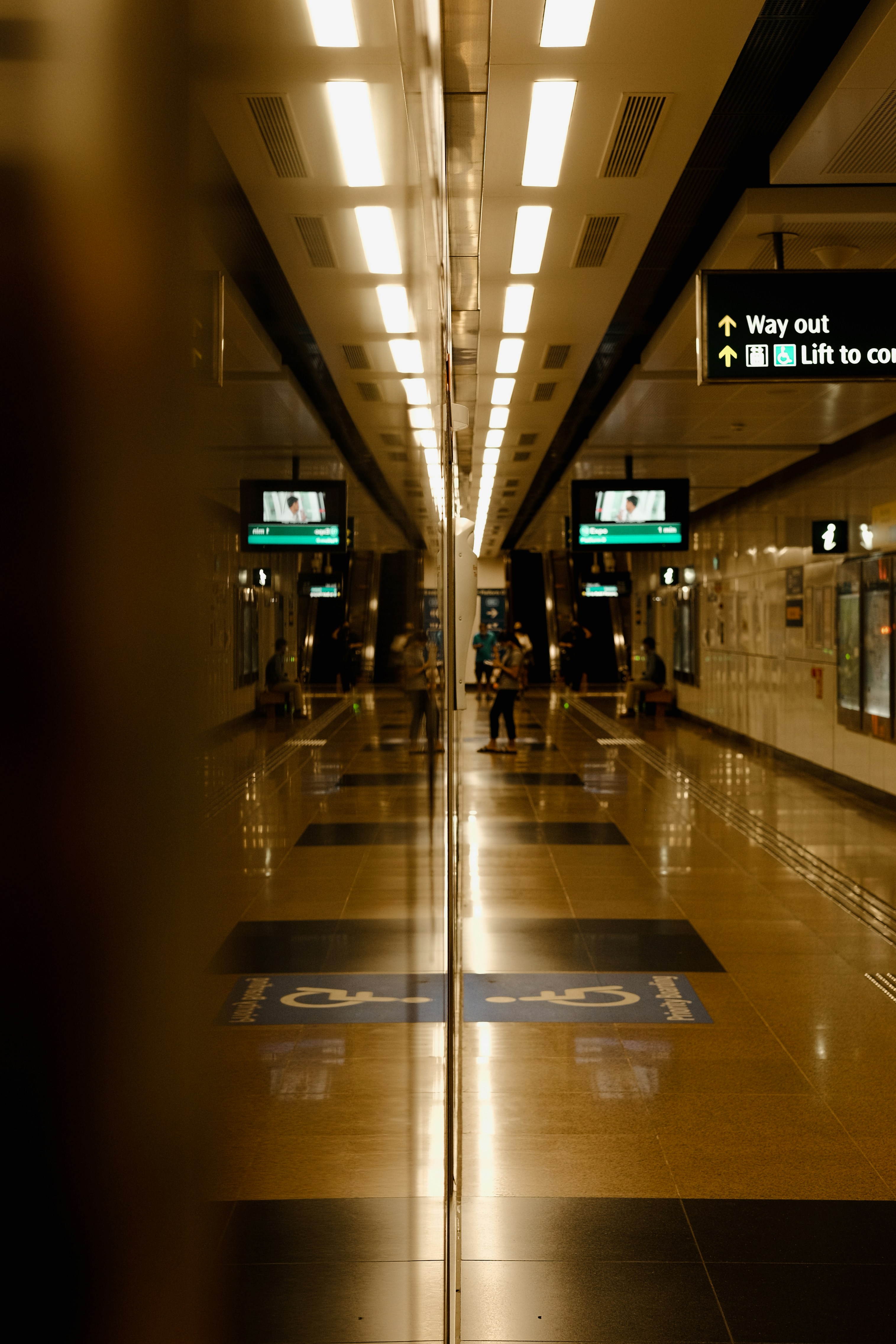 a long hallway with signs and lights on the ceiling