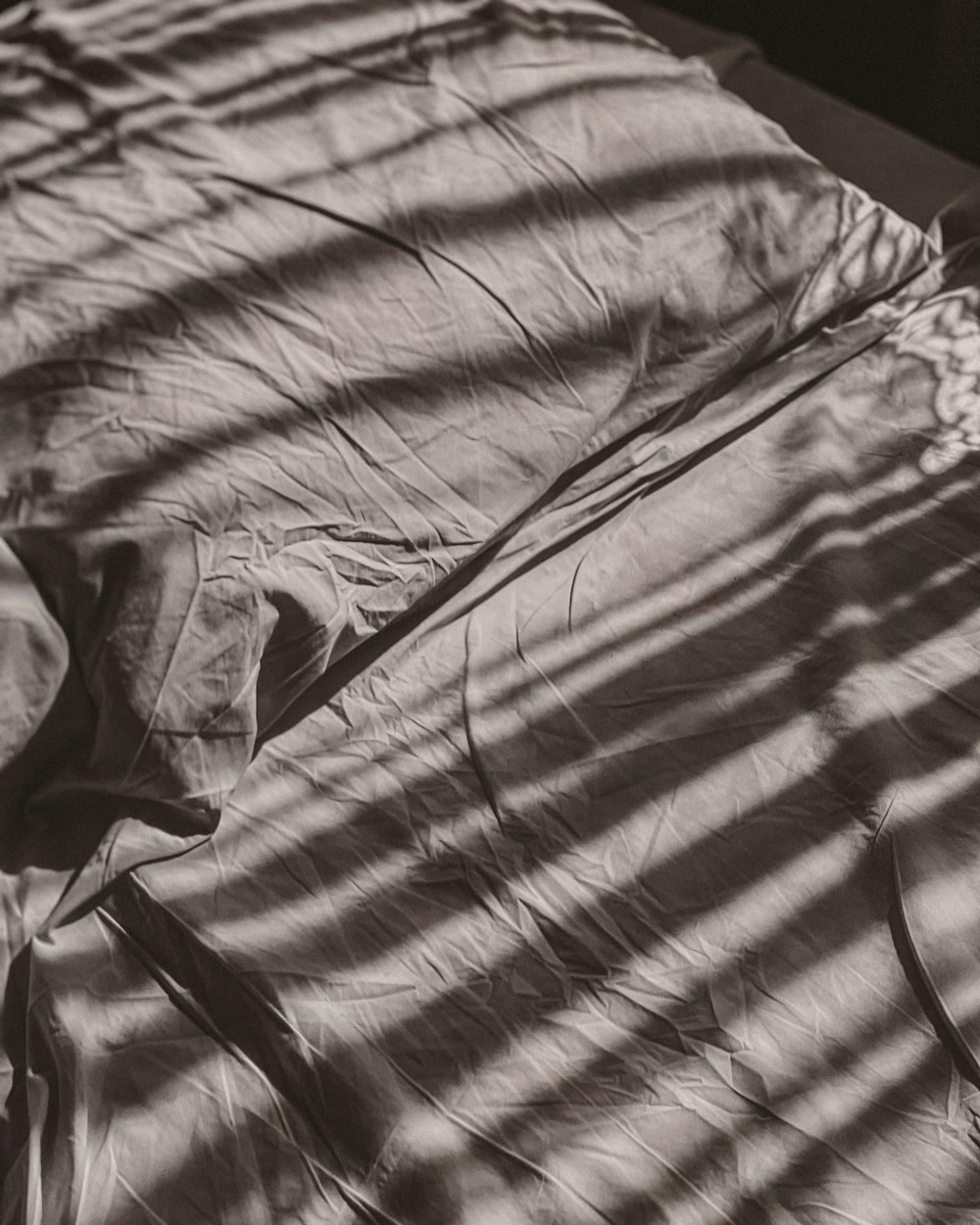 a black and white photo of an unmade bed