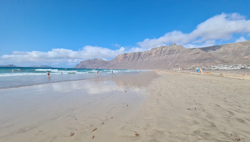 a sandy beach with a mountain in the background