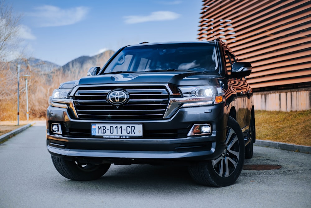 Un Toyota Land Cruiser noir garé devant un immeuble