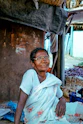 a woman sitting on the ground in front of a building