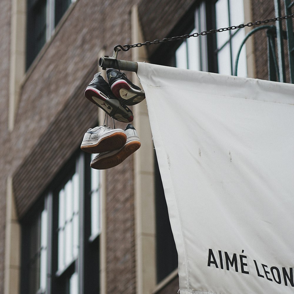 a pair of shoes hanging from a chain near a building