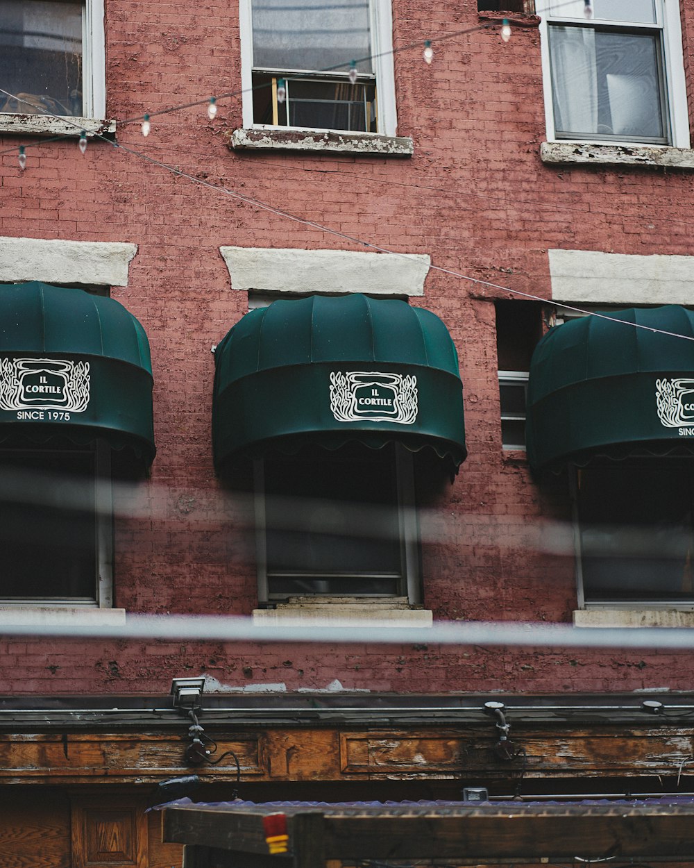 a red brick building with three green awnings