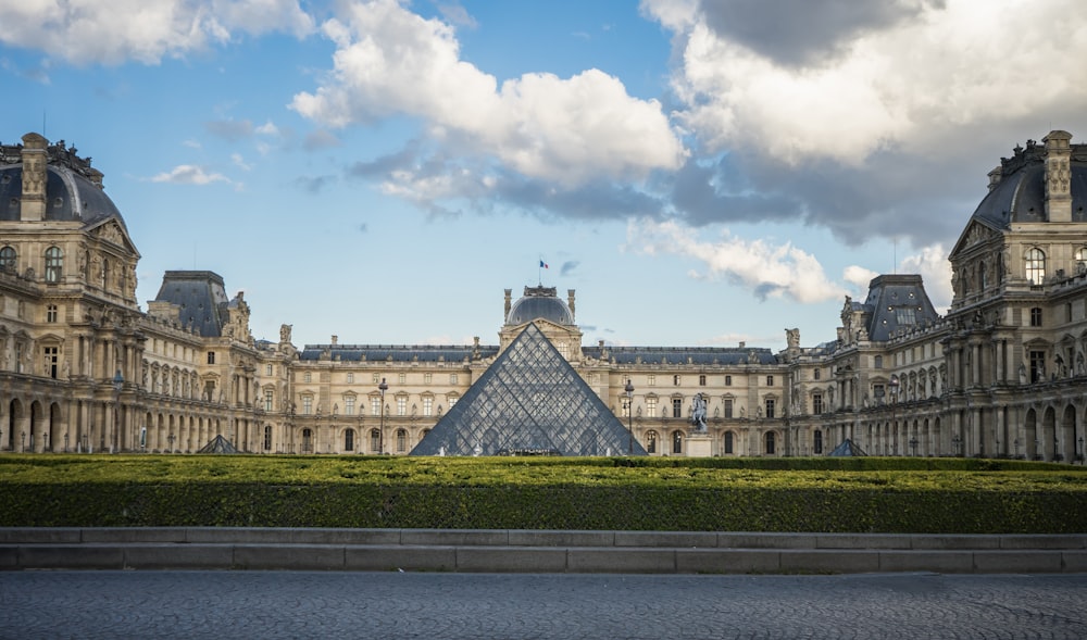 un grande edificio con una piramide di vetro di fronte ad esso