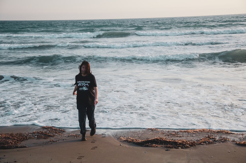 a man standing on a beach next to the ocean