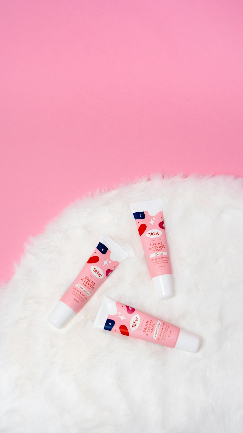 three tubes of hand cream sitting on a white fluffy surface
