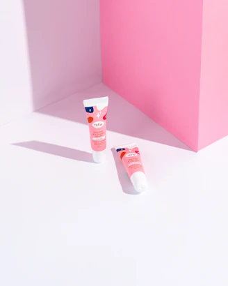 Brightly colored lip balms and tinted lip treatments arranged on a soft fabric background.