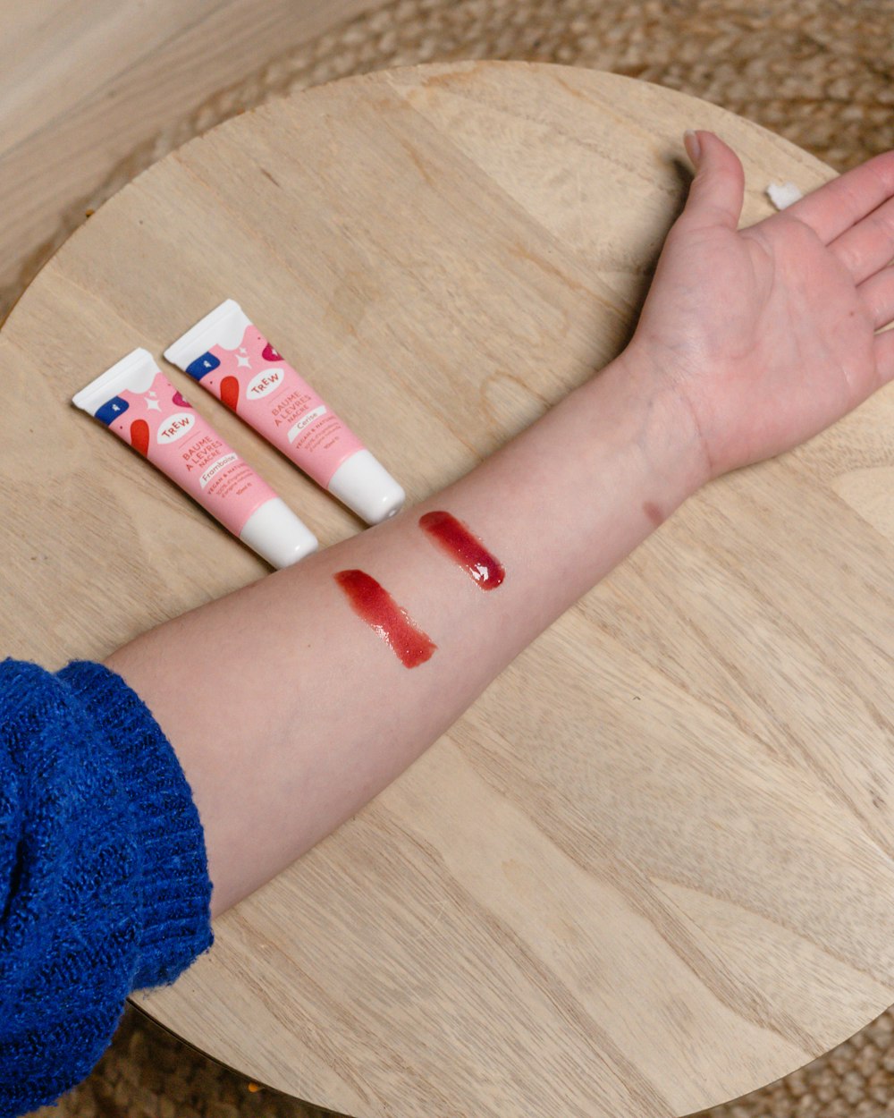 a person's arm with three tubes of lipstick on it