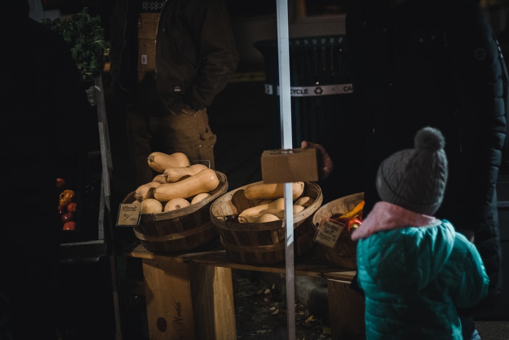 a little boy standing in front of a table full of food