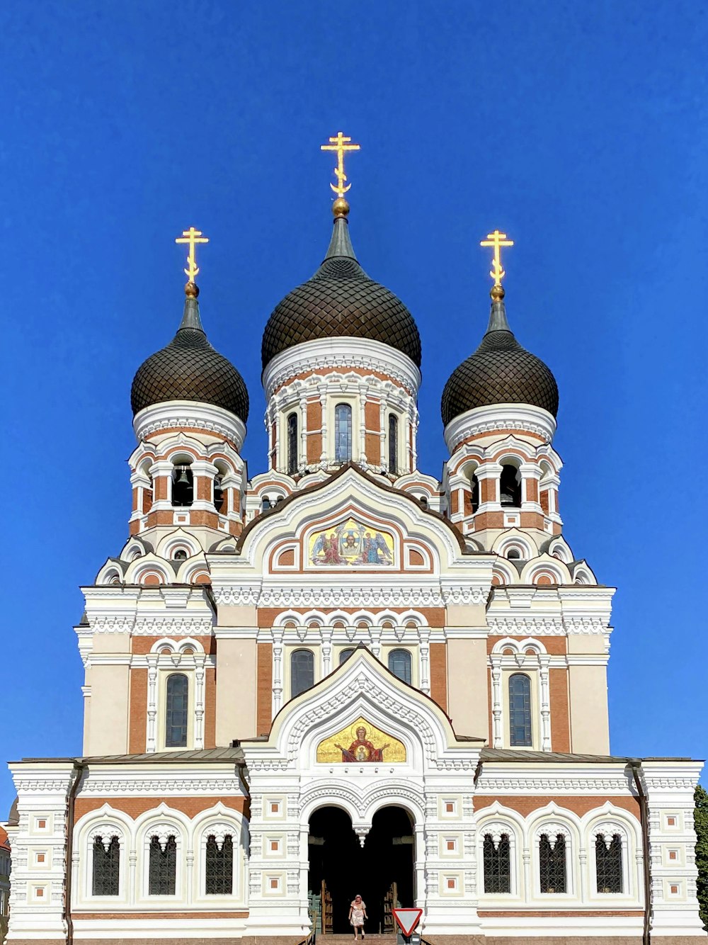 a large white and brown building with a cross on top