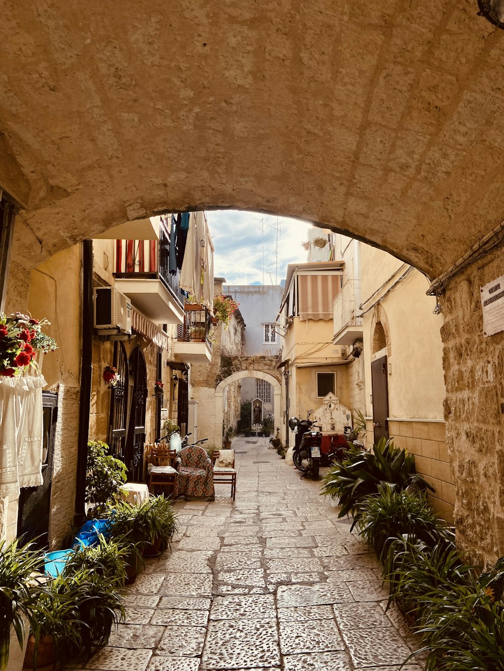 a cobblestone street with a stone arch in the middle