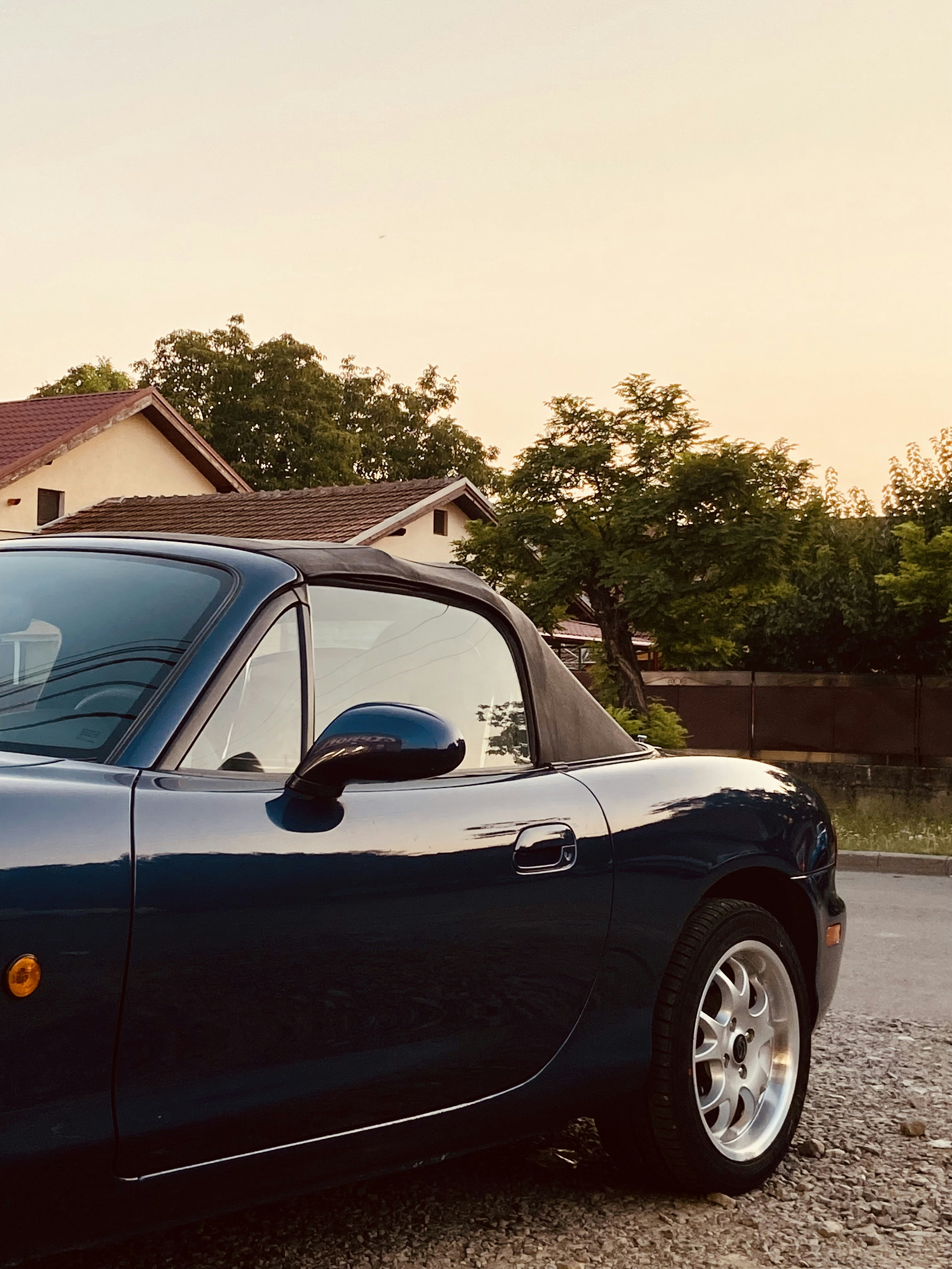 Une voiture de sport bleue garée devant une maison