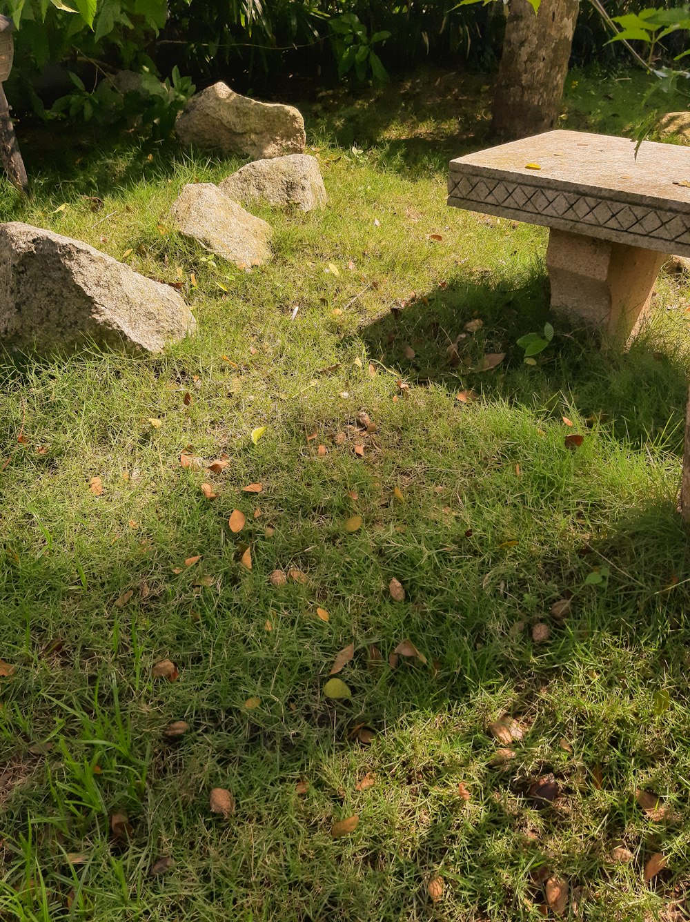 a stone bench sitting on top of a lush green field