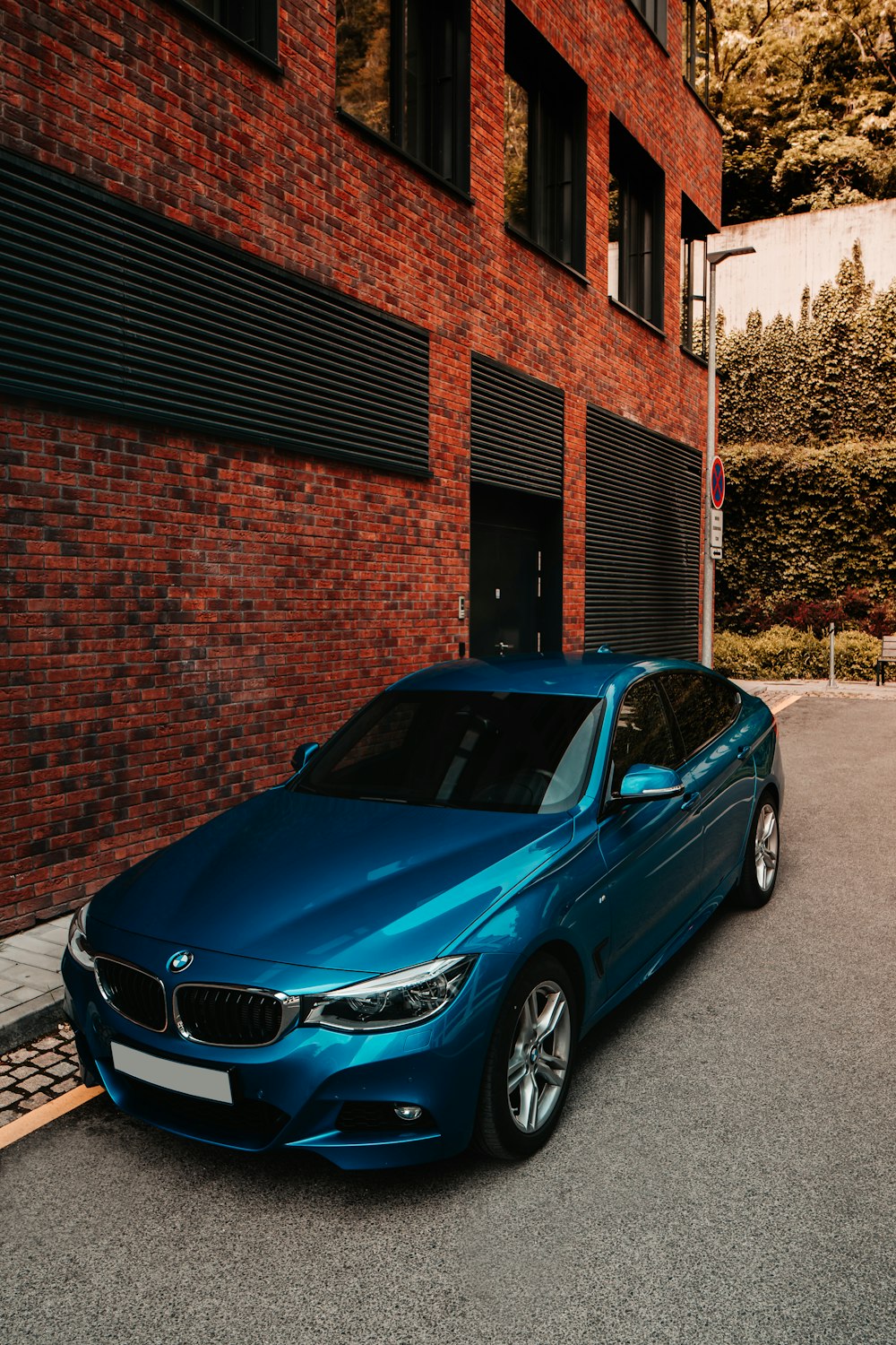 a blue car parked in front of a brick building