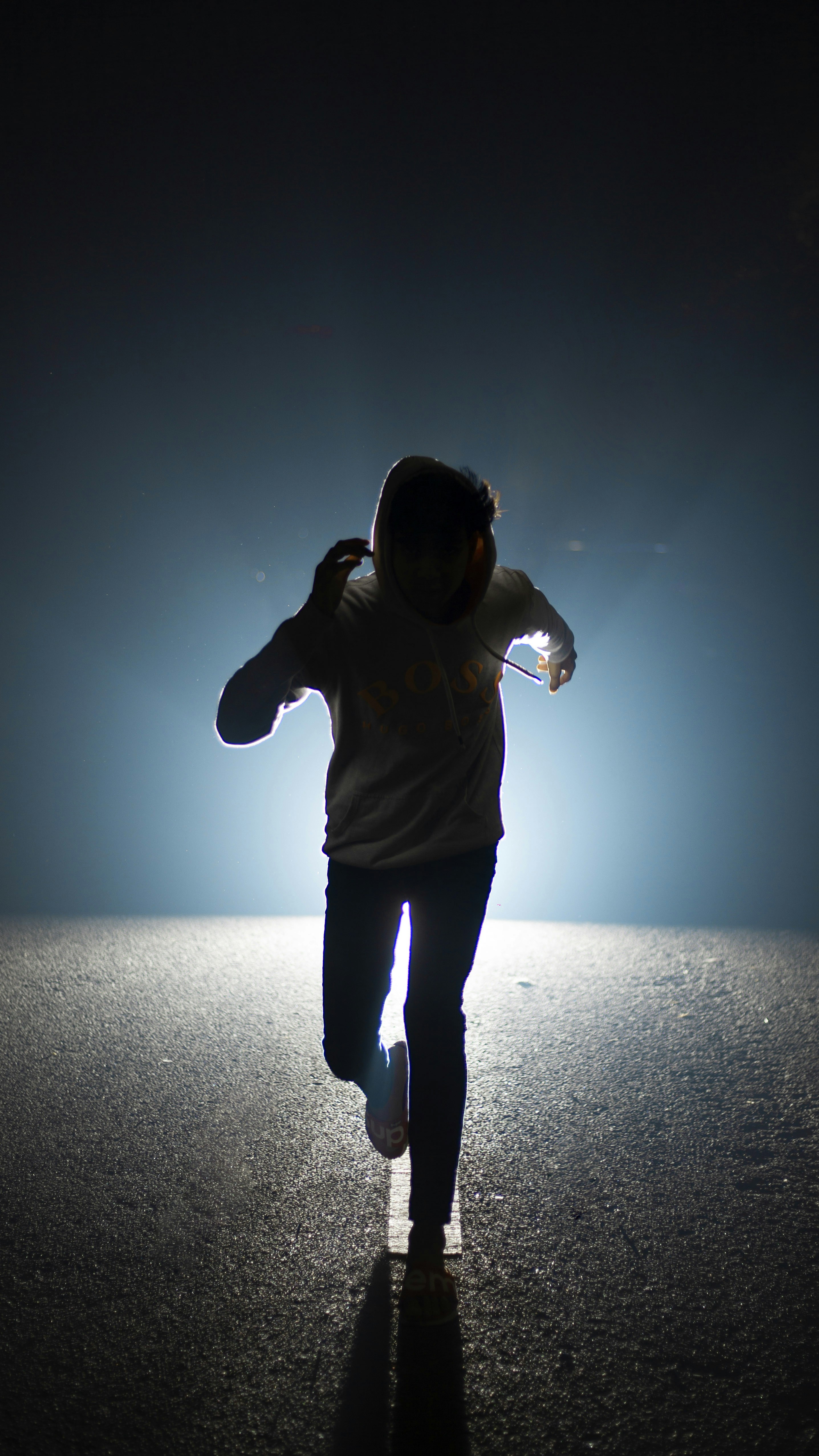 a person walking in the middle of the road at night
