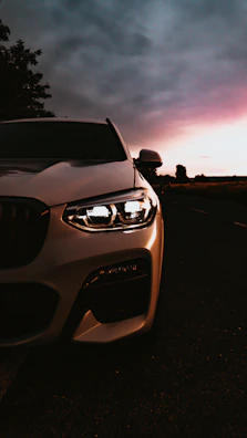 Front view of a sleek new compact car on a coastal road at sunset