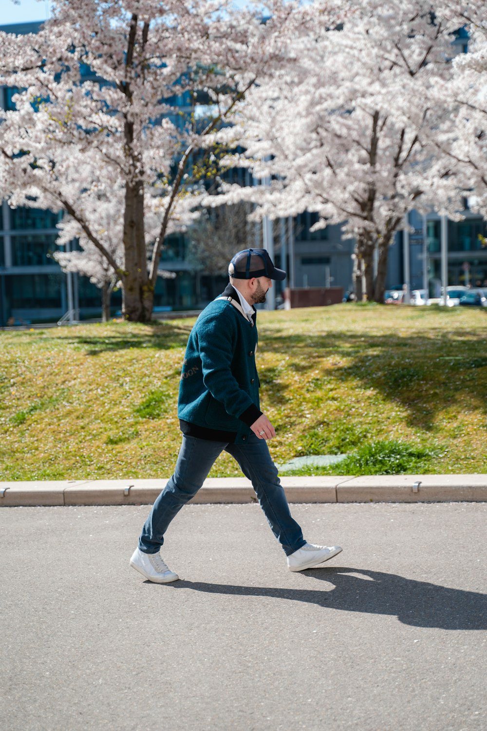 a man walking down the street in front of some trees