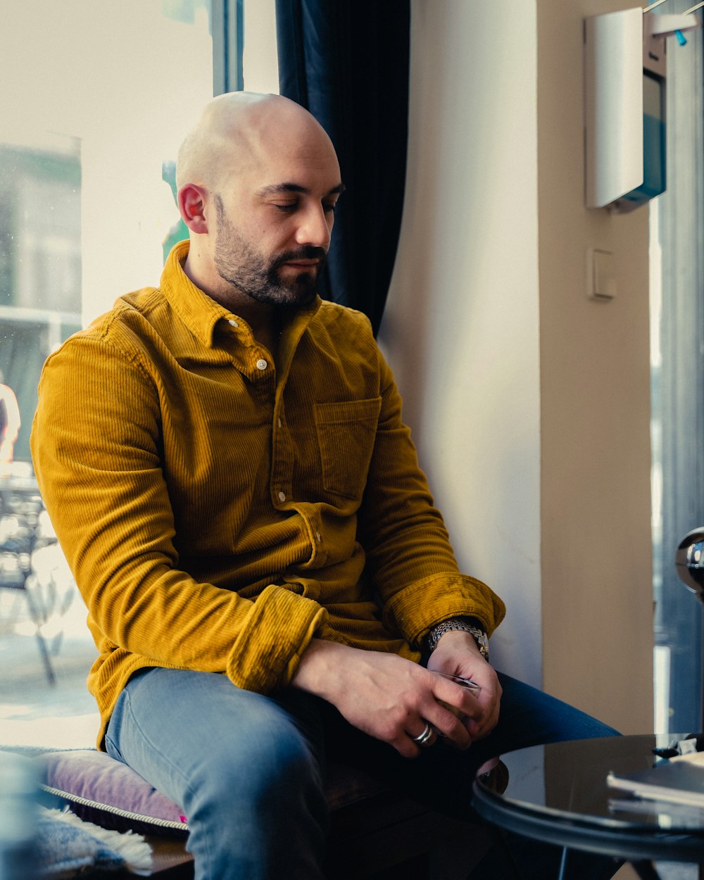 a man with a bald head sitting in a chair