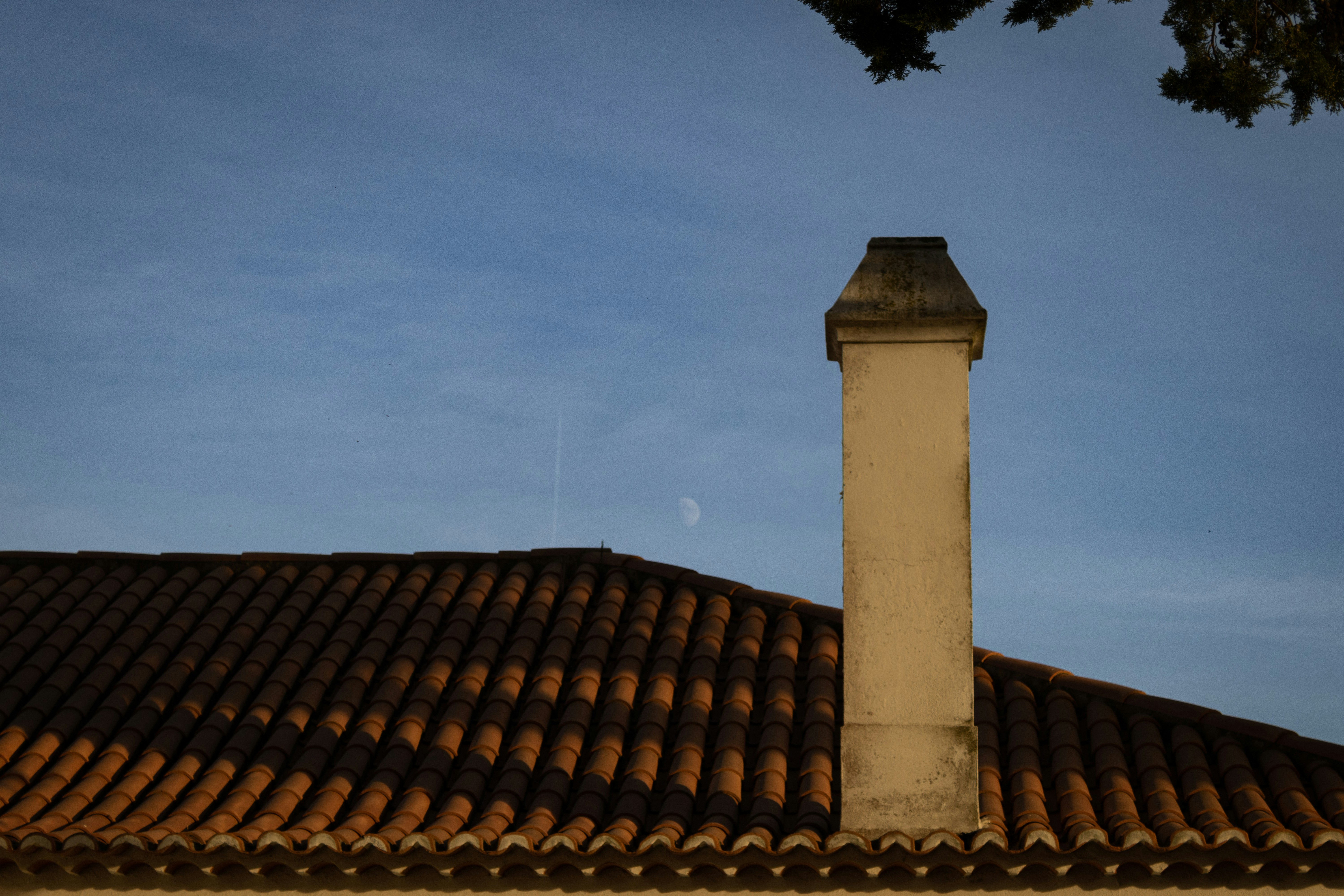 a tall chimney on top of a tiled roof