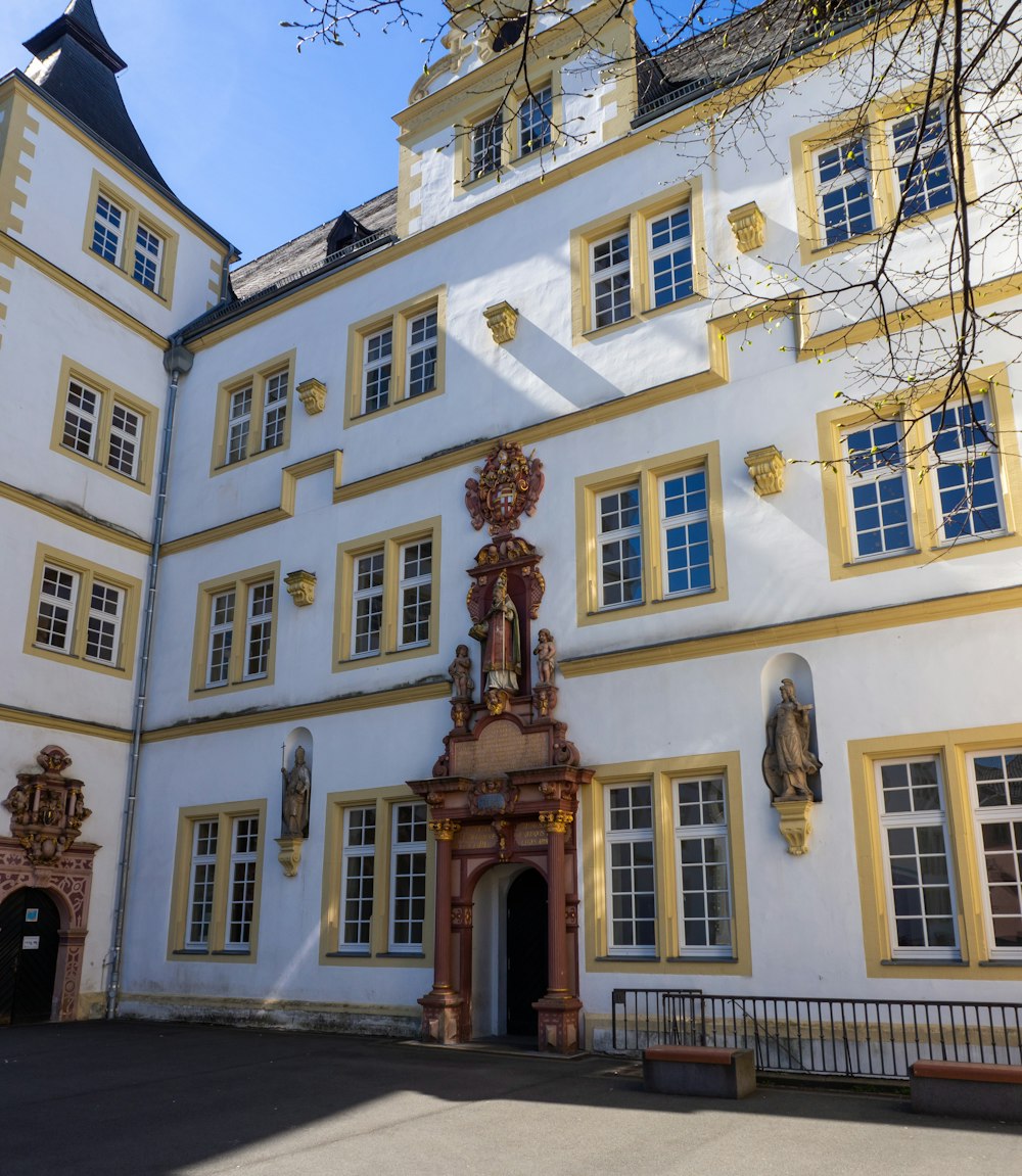 a large white building with yellow trim and windows