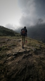 a man with a backpack walking up a hill