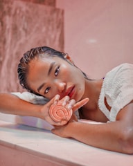 a woman laying on a counter holding a lollipop