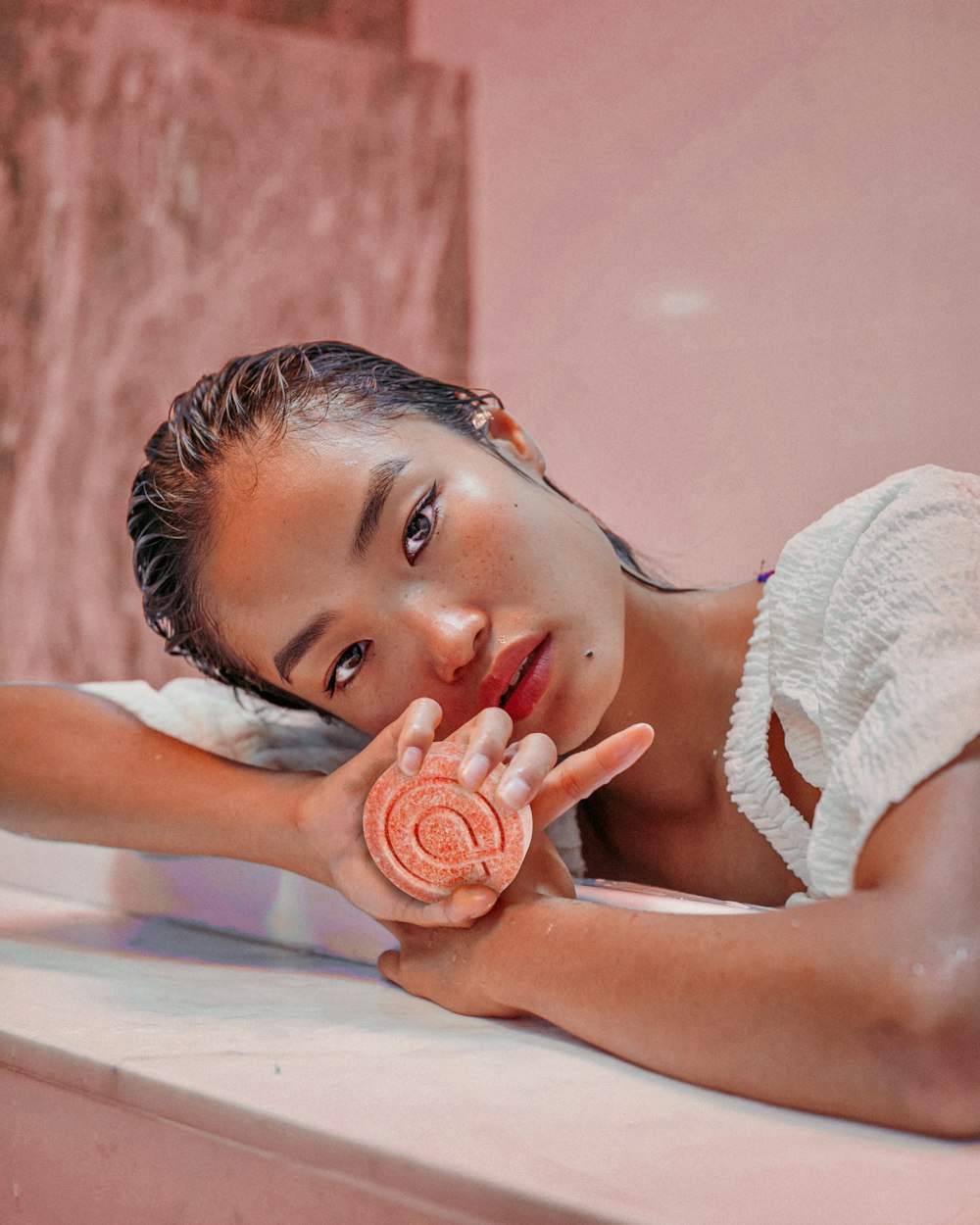 a woman laying on a counter holding a lollipop