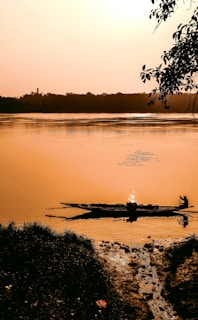 A serene river scene at sunset near Puerto Leguízamo with canoes floating gently.